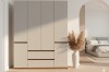 Moderner grauer Schrank im Schlafzimmer-Ambiente mit Bett und Pampasgras in einer Vase.