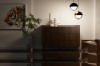 Elegantes Sideboard in dunkler Walnuss-Optik mit Rillenfront vor einer hellen Wand mit Tiger-Bild.