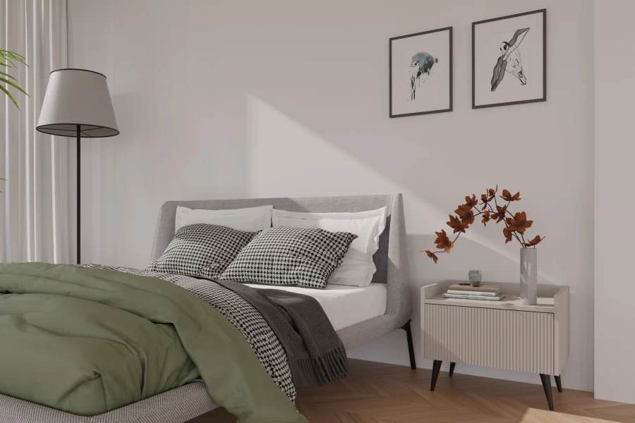 Gemütliches Schlafzimmer mit grauem Polsterbett, grüner Bettwäsche und modernem weißen Nachttisch.