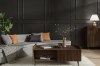Gemütliches Wohnzimmer mit grauem Sofa, hölzernem Couchtisch und dunkler Wandgestaltung.