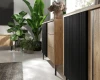 Detailansicht Sideboard Eiche mit schwarzer Lamellenfront und Dekoration.