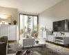 Helles Wohnzimmer mit weißen Möbeln, TV-Unterschrank und Couchtisch in Lamellenoptik.