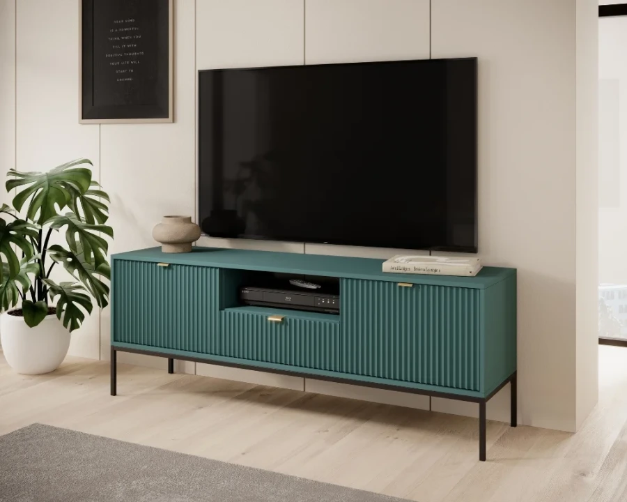 Modernes grünes TV-Lowboard mit geriffelter Front im Wohnzimmer neben einer Pflanze.