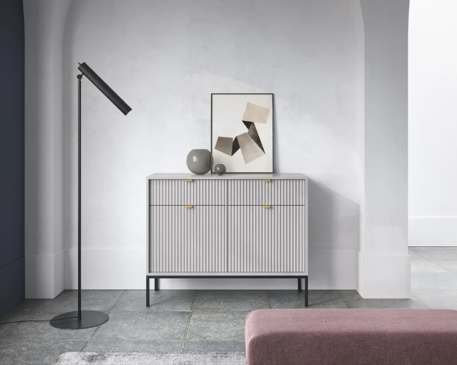 Modernes Sideboard in Weiß mit Riffel-Optik in einer minimalistischen Inneneinrichtung.