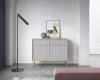 Modernes Sideboard in Grau mit Riffel-Front und goldenen Füßen im Wohnzimmer.