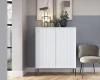 Moderner weißer Schrank mit Strukturfront im Wohnzimmer neben grauem Sessel.