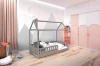 Stilvolles Kinderzimmer mit grauem Hausbett, Berg-Wanddeko und rosa Kleiderschrank.