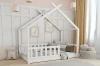 Weißes Hausbett aus Holz für Kinder mit Rausfallschutz in gemütlich eingerichtetem Zimmer.