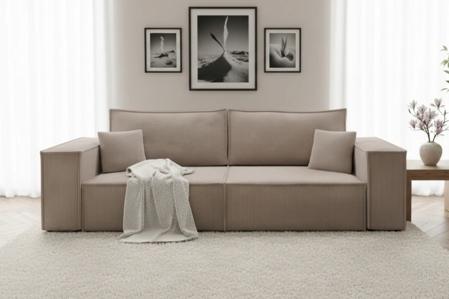Stilvolles taupefarbenes Cord-Sofa in einem hellen Wohnzimmer-Ambiente mit Wandbildern