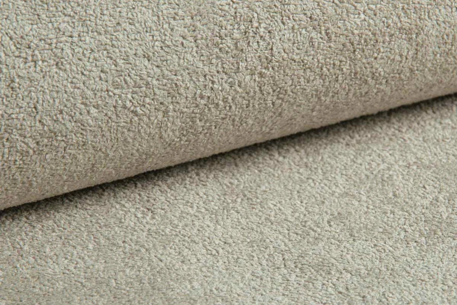 Detailaufnahme von hochwertigem Bouclé-Stoff in Beige für moderne Polstermöbel.
