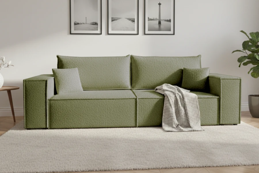 Grünes Sofa im modern eingerichteten Wohnzimmer mit hellem Teppich und Wandbildern.