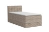 Beige Boxspringbett aus Cord-Stoff mit gepolstertem Kopfteil und weißem Topper auf weißem Hintergrund.