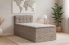 Modernes beige Cord-Boxspringbett in einem hellen Schlafzimmer mit Pflanze und Weltkarte an der Wand.