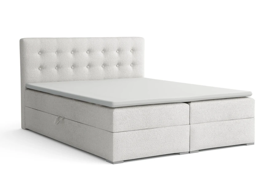 Weißes Cynthia Lux Boxspringbett mit gestepptem Kopfteil und integriertem Bettkasten auf weißem Hintergrund.