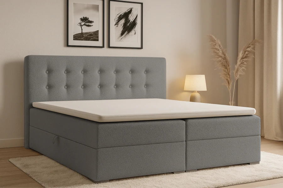 Graues Boxspringbett mit gestepptem Kopfteil in gemütlichem Schlafzimmer.
