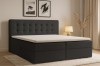 Schwarzes Boxspringbett mit gestepptem Kopfteil im Schlafzimmer-Ambiente.