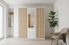 Moderner weißer Kleiderschrank mit Holzlamellen und Spiegel in einem hellen Schlafzimmer-Ambiente.