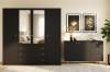 Schwarzes Schlafzimmer-Set mit großem Kleiderschrank und Sideboard in Deko-Ambiente.