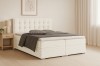 Elegantes Boxspringbett in Beige im gemütlichen Schlafzimmer mit Nachttisch und Lampe.