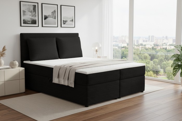 Zwart boxspringbed met hoog hoofdbord in een moderne kamer met uitzicht op de stad.