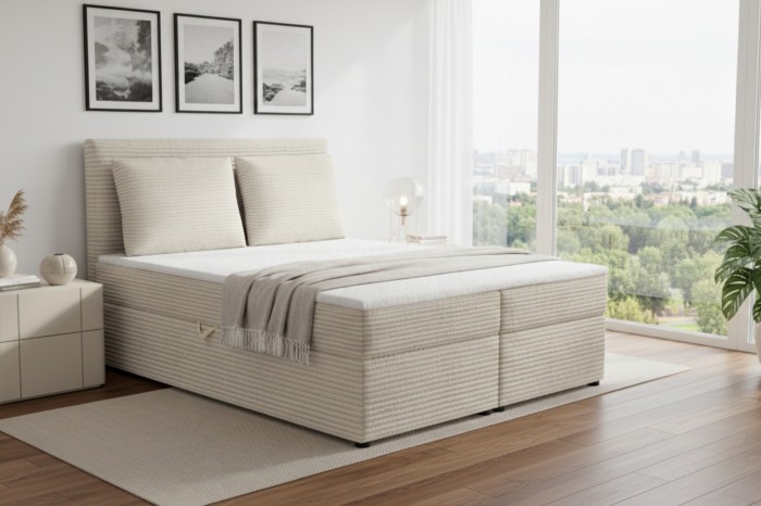 Beige boxspringbed met ribstof bekleding in een lichte slaapkamer met uitzicht op de stad.