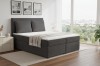 Dunkelgraues Boxspringbett mit Cord-Bezug in einem modernen Zimmer mit Ausblick.
