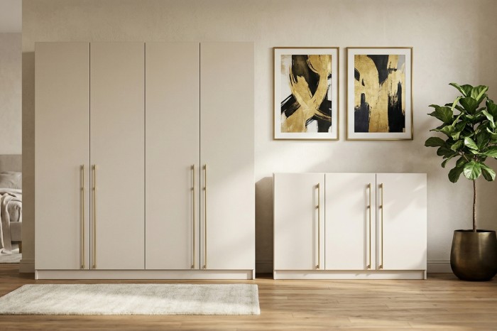 Moderner beige Schrank und Sideboard mit goldenen Griffen vor einer Wand mit abstrakter Kunst