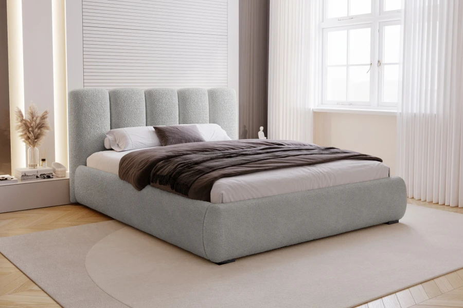 Modernes Schlafzimmer mit hellgrauem Polsterbett, beigem Teppich und hellem Fenster.