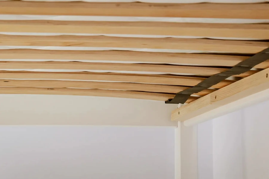 Stabiler Holz-Lattenrost für ein Kinderbett mit flexiblen Leisten und schwarzem Halteband.