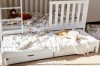 Weißes Kinderbett mit praktischem Ausziehbett und zwei Schubladen im Kinderzimmer.