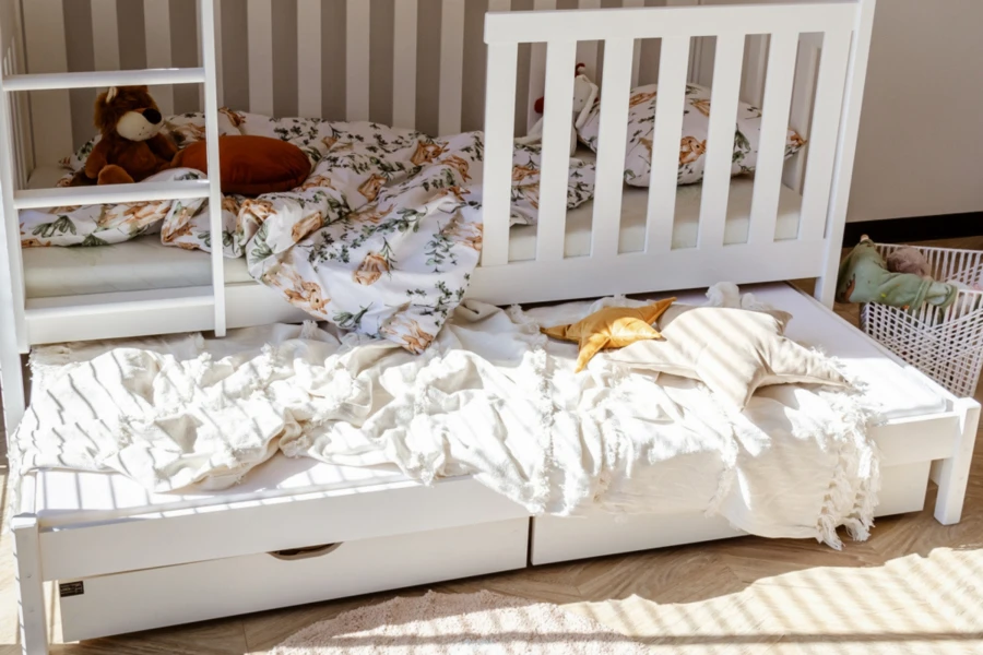 Weißes Kinder-Etagenbett mit Leiter und praktischem Ausziehbett für Übernachtungsgäste.
