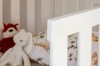 Nahaufnahme vom weißen Rausfallschutz am Kinderbett mit abgerundeten Kanten.