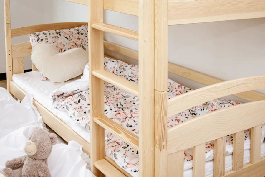 Etagenbett aus Kiefernholz mit Leiter und blumiger Bettwäsche im Kinderzimmer.