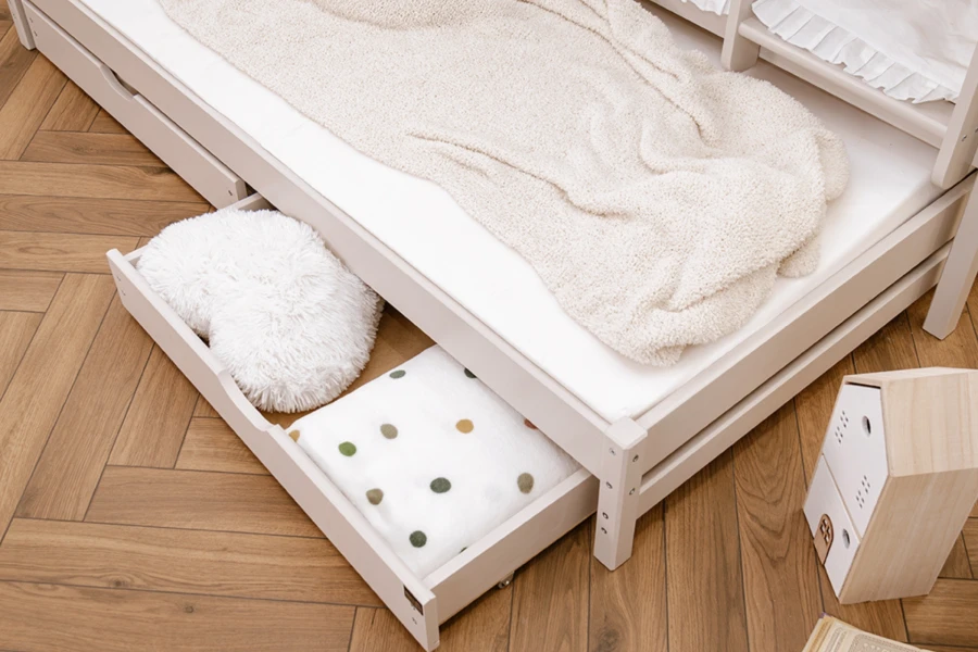 Ausziehbare Bettschublade unter einem Etagenbett bietet praktischen Stauraum für Decken und Kissen.