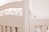 Detailaufnahme eines weißen Etagenbetts aus Holz mit sichtbaren Schraubverbindungen.