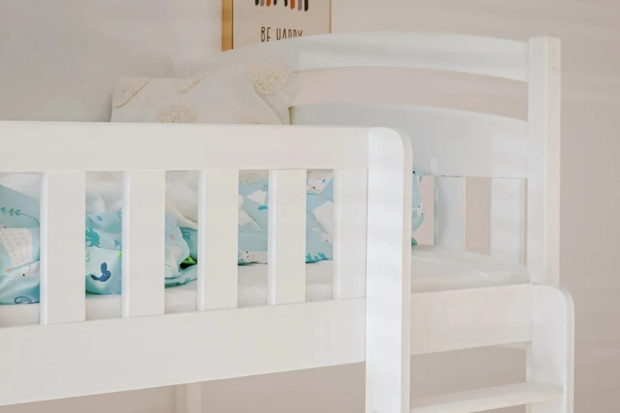 Weißes Etagenbett mit Rausfallschutz und hellblauer Kinderbettwäsche.