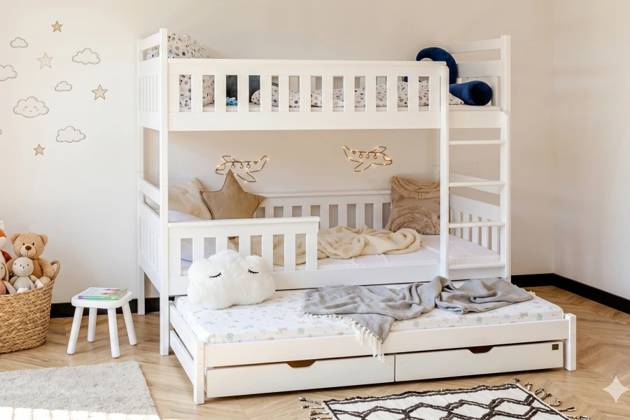 White children's bunk bed with pull-out bed in decorated room.