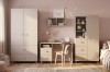 Beiges Kindermöbel-Set mit Schreibtisch, Kleiderschrank und Wandregal im rosa Zimmer.
