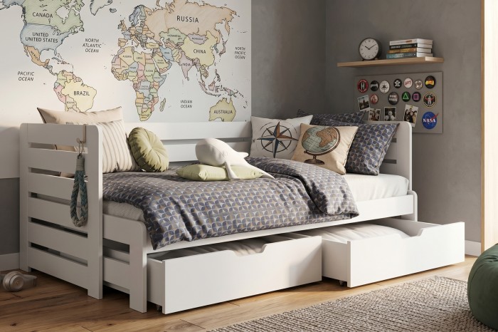 Weißes Kinderbett mit ausziehbarem Bettkasten und Weltkarten-Wandbild im Kinderzimmer.