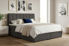 Elegantes graues Boxspringbett mit geriffeltem Kopfteil in einem hellen, modernen Schlafzimmer.