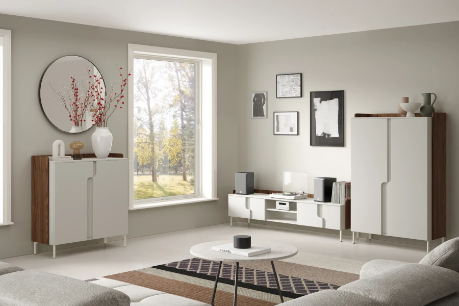 Stilvolles Wohnzimmer mit beigen Sideboards, Wandspiegel und viel Tageslicht.