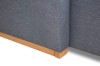 Detailaufnahme der grauen Webstoff-Struktur und der hellen Holzfüße.