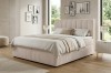 Elegantes Boxspringbett in Beige im Schlafzimmer-Ambiente mit Dekoration.