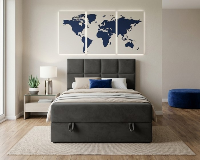 Modernes Polsterbett in Anthrazit mit integriertem Bettkasten und blauem Pouf im Raum.