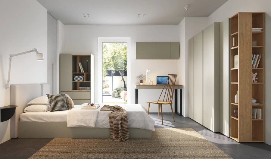 Helles Schlafzimmer mit salbeigrünen Schränken, Holzregal und gemütlichem Bettbereich.