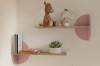Zwei Wandregale aus Holz mit rosa Dekoelementen für Spielzeug und Bücher