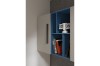 Modernes blaues Wandregal mit Flip-Clock und Büchern neben beigem Schrank.