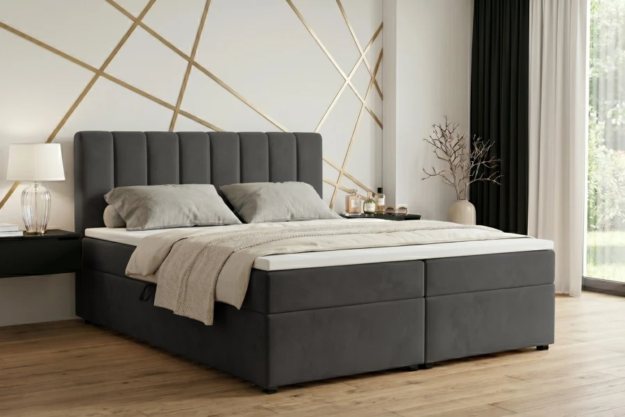 Dunkelgraues Boxspringbett in Anthrazit mit vertikal gestepptem Kopfteil in einem modernen Schlafzimmer.