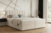 Cremefarbenes Boxspringbett in einem stilvoll eingerichteten Schlafzimmer.