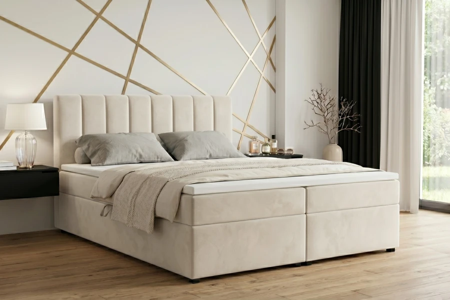 Cremefarbenes Boxspringbett in einem stilvoll eingerichteten Schlafzimmer.
